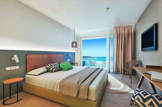 Hotelzimmer im Boho Stil mit Blick &uuml;ber das Bett hin zum Balkon mit Meerblick